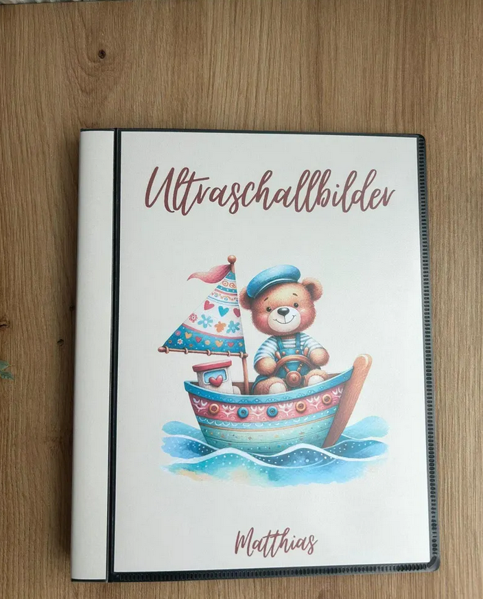 Personalisierbares Ultraschallalbum Matrosen Bär mit Aufschrift Ultraschallbilder und Name Matthias auf Holztisch