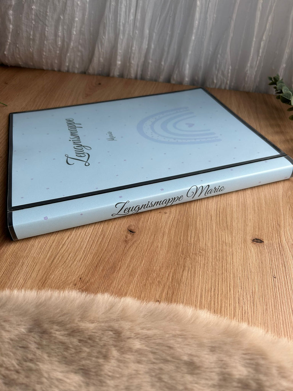 Zeugnismappe Mario in Hellblau mit bedrucktem Seiteneinband auf Holztisch – stabiles Hardcover